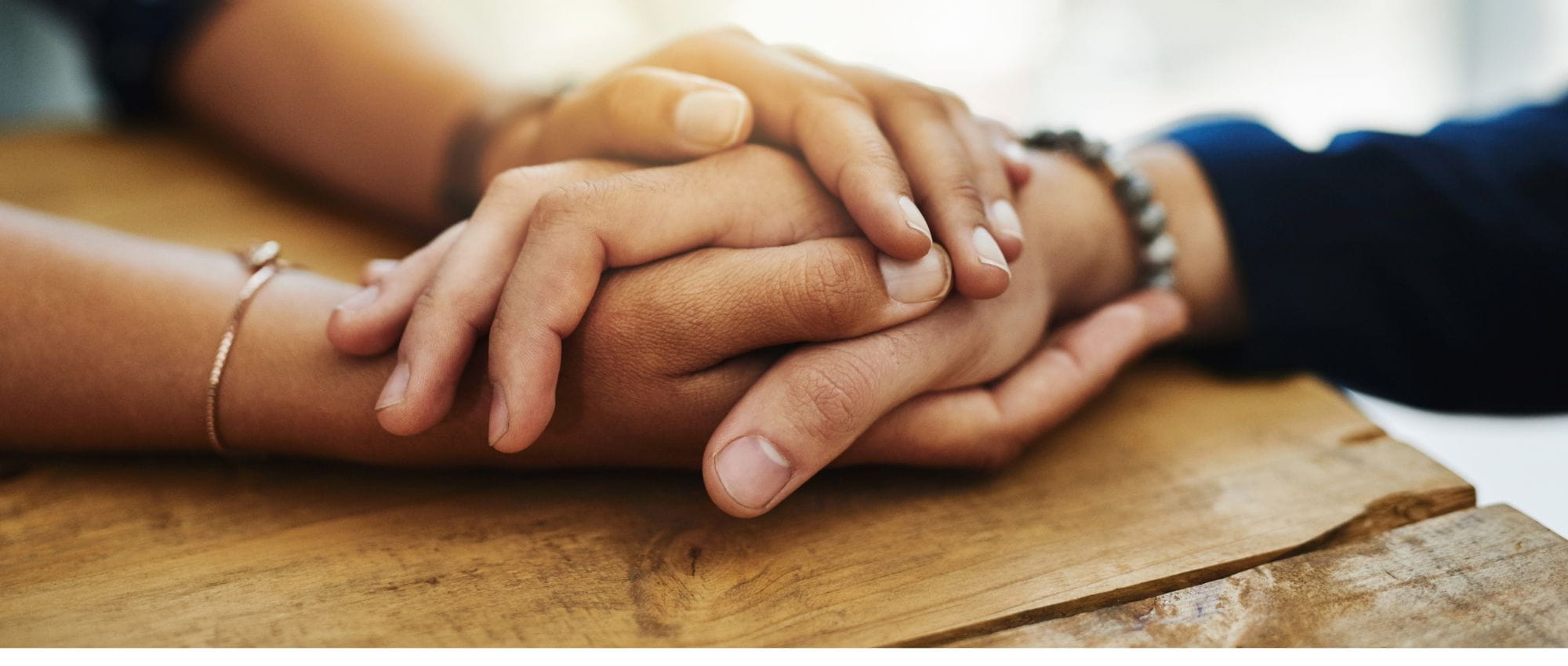 A couple of women holding hands and learning about the blog about women's mental health and addiction treatment at Luna Recovery for Women in North Andover, MA.